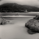 Black-white Mediterranean sea waterscape with blurry water, bird on the rocks and lighthouse, long exposure daytime image, archival fine art print for sale