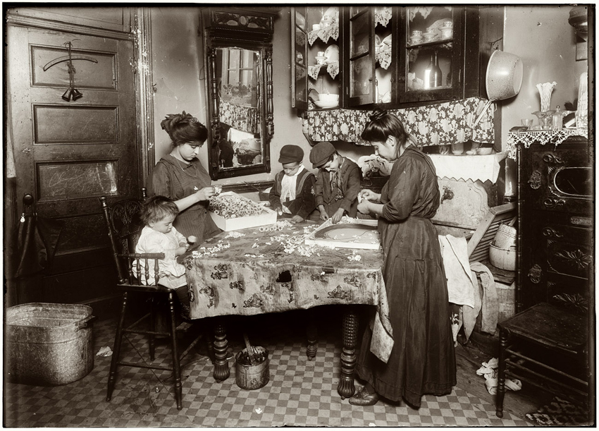 Black-white documentary photograph of Family of Mrs. Mette making flowers in a very dirty tenement
